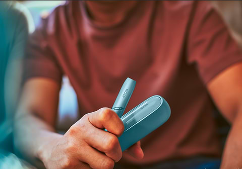 Мужчина держит в руке IQOS 3 DUOS Originals